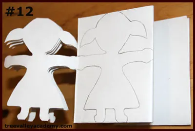 Cutting out one layer at a time of a 4 row 4 column paper doll chain. A fun art project to do with kids.