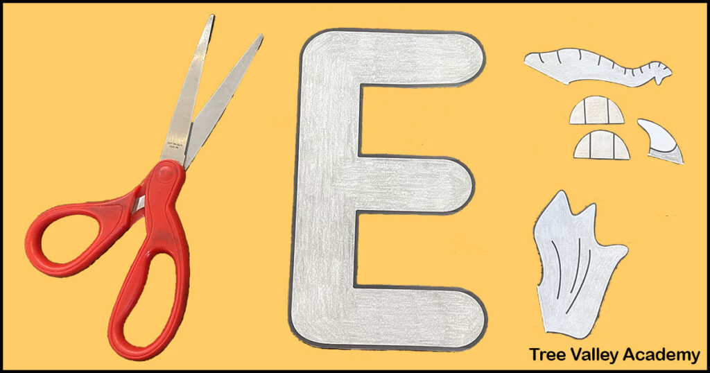 Step 2 of a letter E preschool alphabet craft: cutting out the uppercase letter E, and the elephant's trunk, ear, tusk, and toenails.