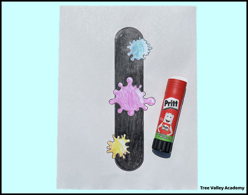 Completed uppercase letter I ink craft with glue stick and ink splats