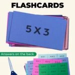 Free printable multiplication flashcards with answers on the back. There's a stack of printed flashcards on colorful cardstock sheets, 12 flashcards per page. There's a pair of scissors to cut the flashcards out, and a stack of cut out flashcards.